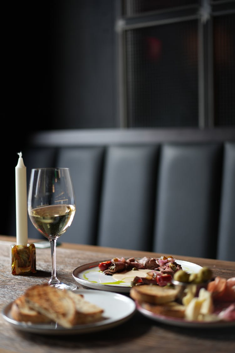 Plates With Dinner, A Glass Of Wine And A Candle