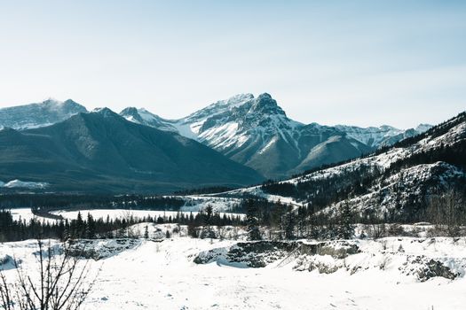 Breathtaking winter view of snow-covered mountains and forests in Kananaskis, Alberta, Canada.