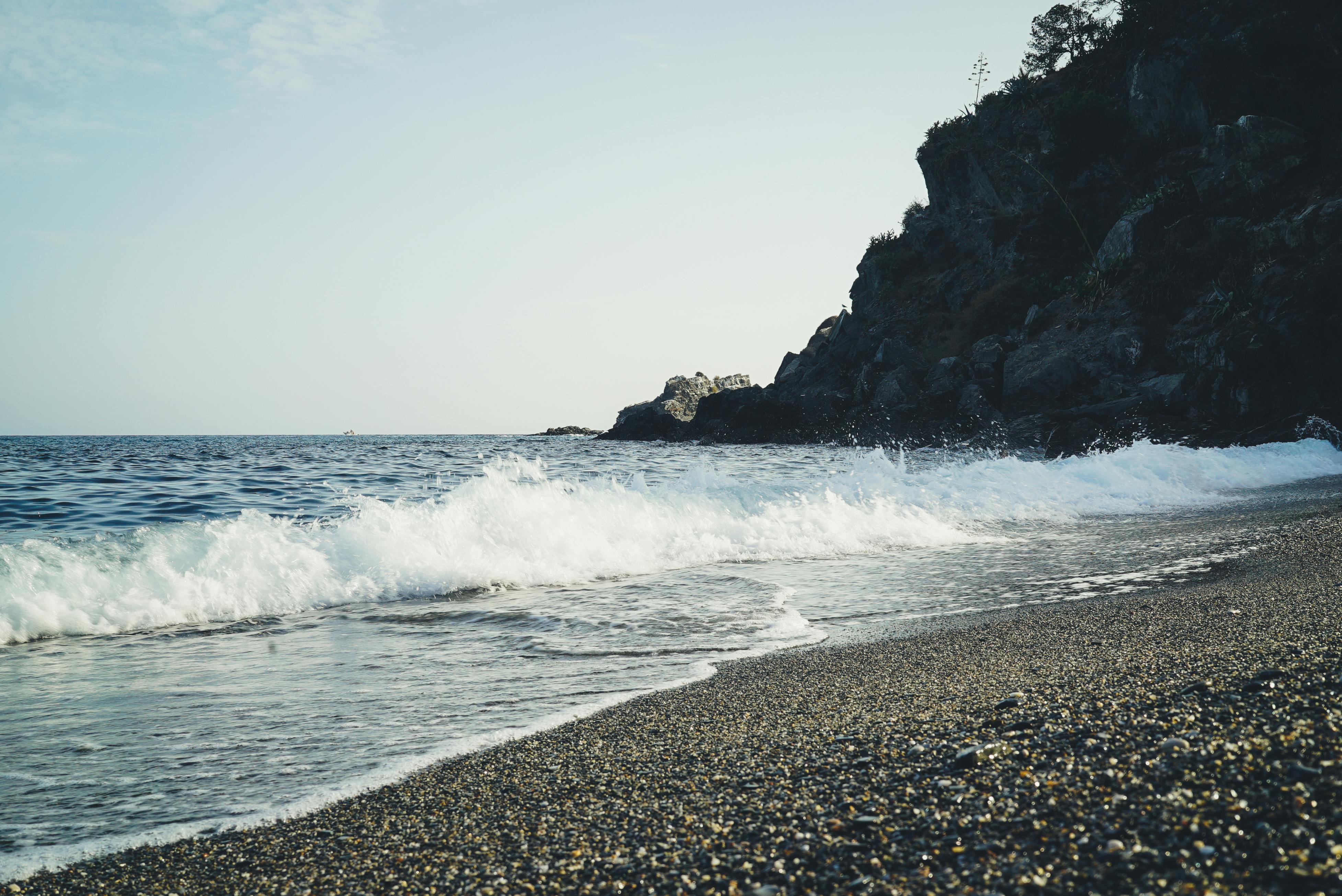 Tranquil seashore scenery with waves crashing against rocks in Granada, Spain.