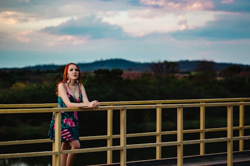 Kostenlos Frau, Die Sich Auf Gelben Stahlzaun Auf Brücke Stützt Stock-Foto