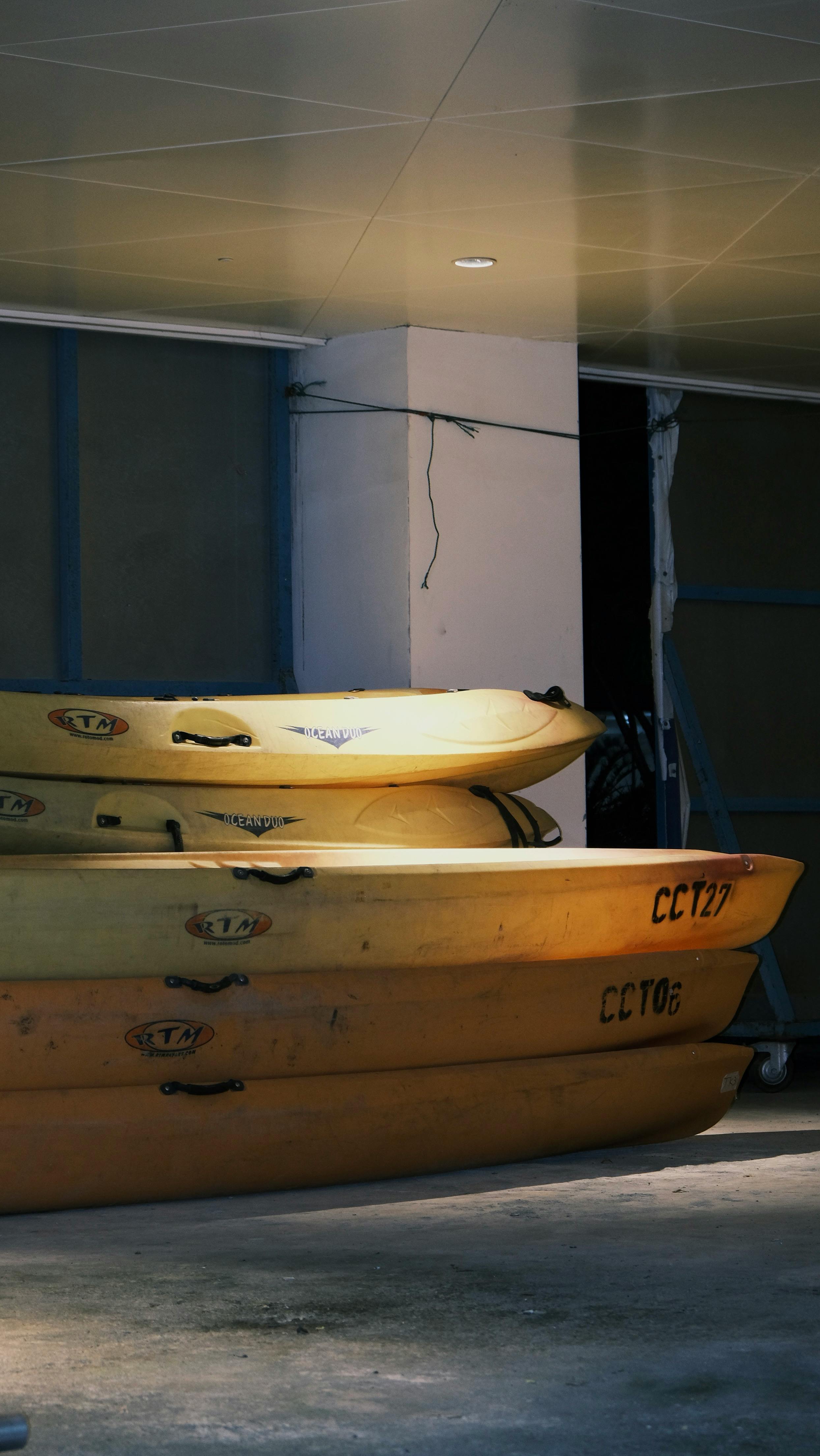 Stacked yellow canoes in indoor lighting at a storage space. Perfect for adventure themes.