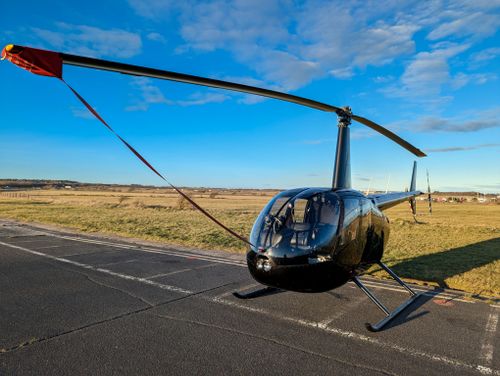 Free Modern black helicopter on airstrip under clear blue skies. Stock Photo