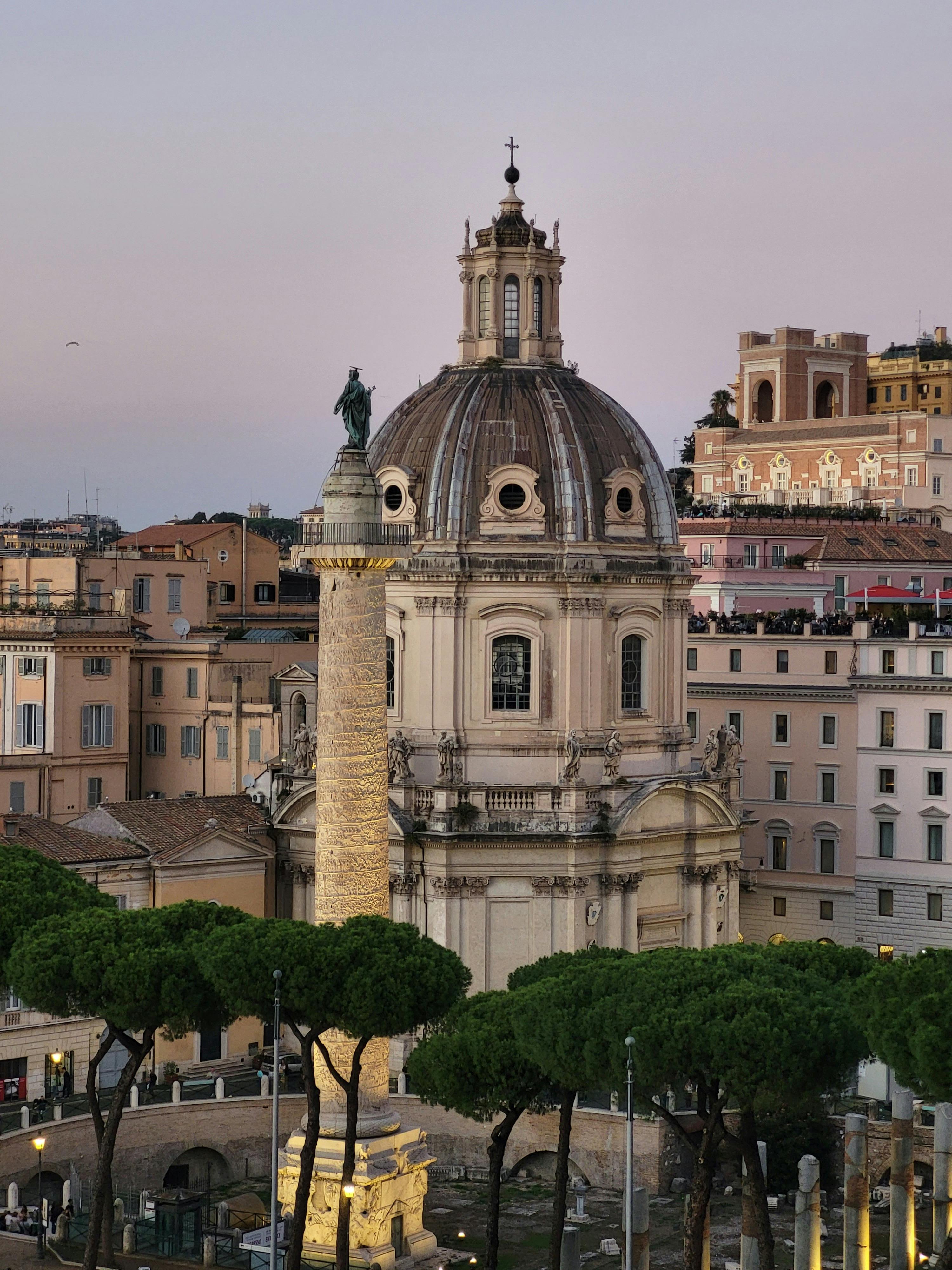Aerial shot of Trajan's Column and the Church of Santa Maria di Loreto at twilight in Rome, Italy.