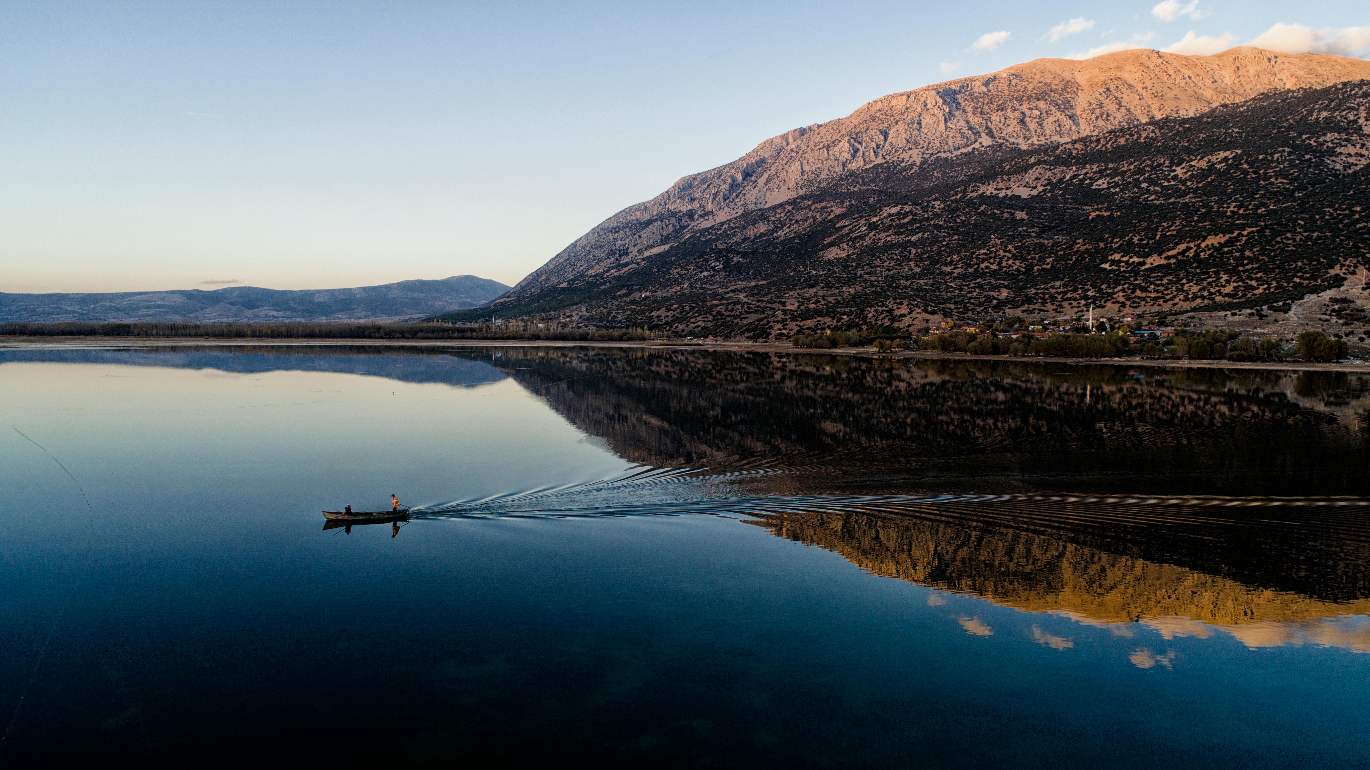 A Man Is Paddling A Boat In A Lake Free Stock Photo   Free Photo Of A Man Is Paddling A Boat In A Lake 