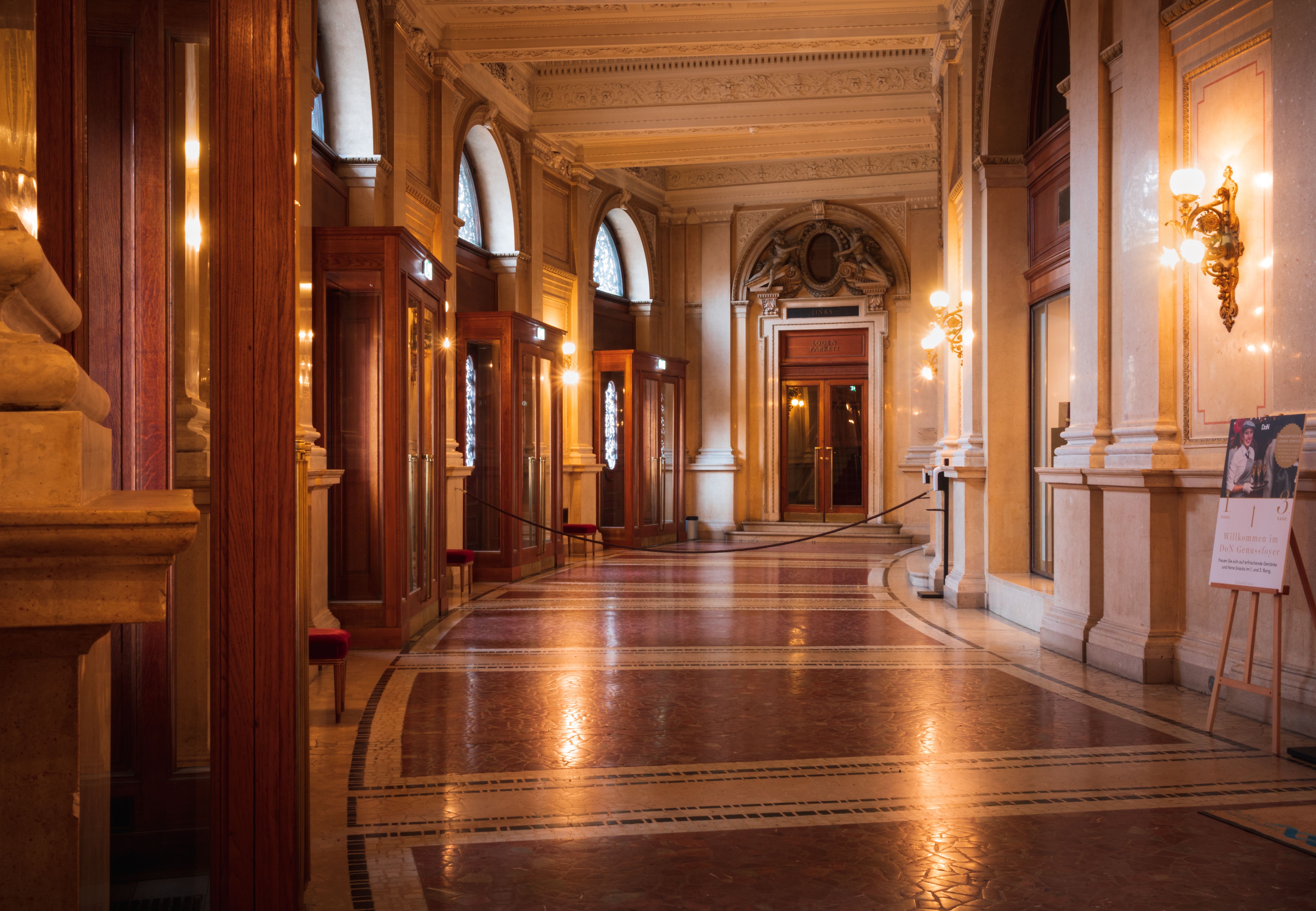 A long hallway with ornate columns and doors · Free Stock Photo