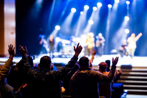 Free Excited crowd at a lively concert with dramatic stage lighting and live music atmosphere. Stock Photo