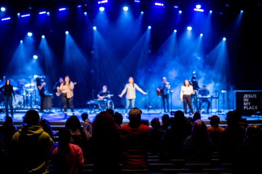 Energetic live band performing on stage with audience enjoying the night concert.