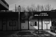 Black and white photo of a French hand car wash exterior in winter.