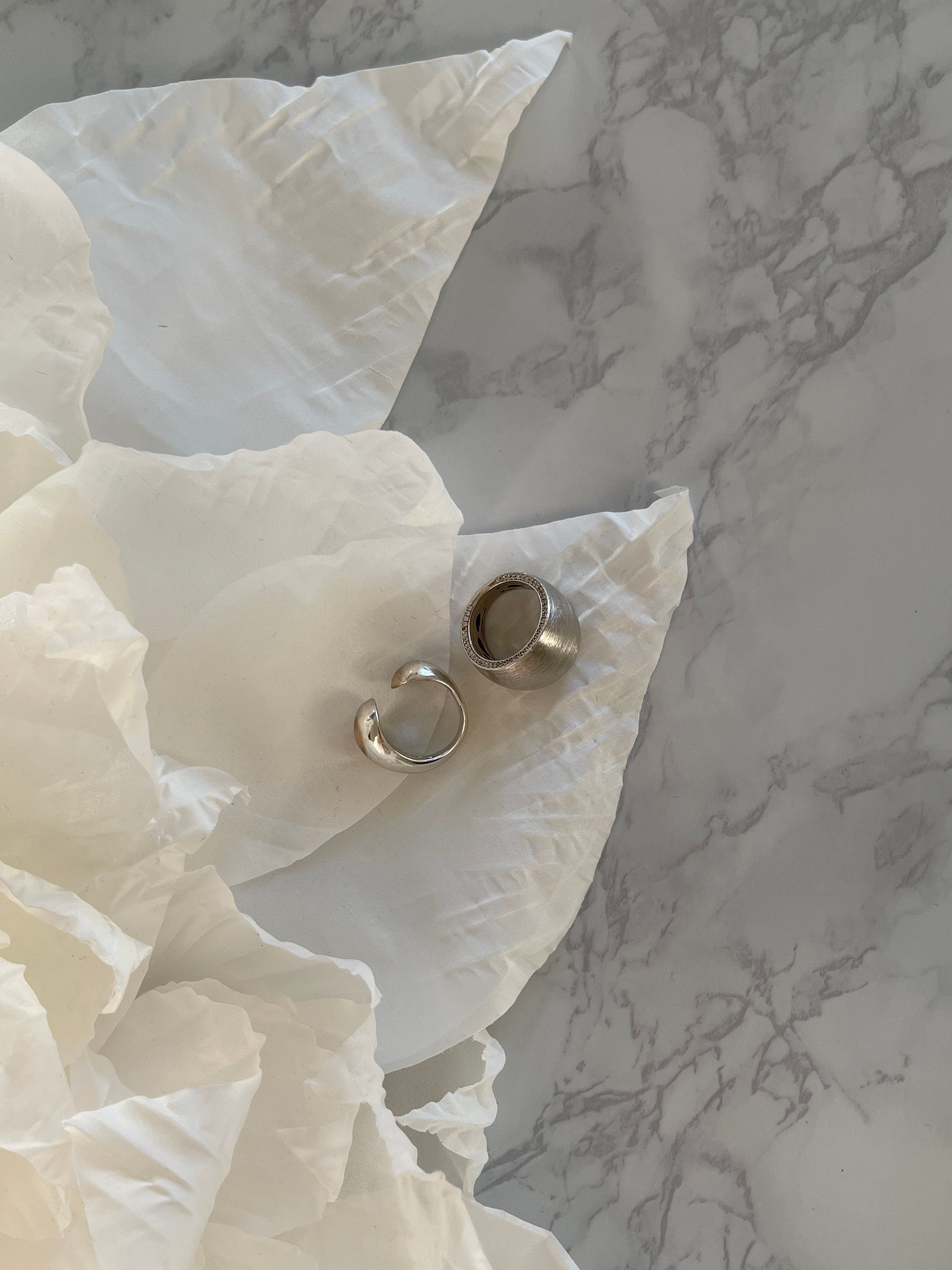 Elegant Metal Rings on White Fabric · Free Stock Photo