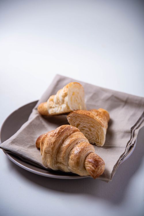 Free Tantalizing close-up of flaky croissants on a plate, perfect for food lovers. Stock Photo