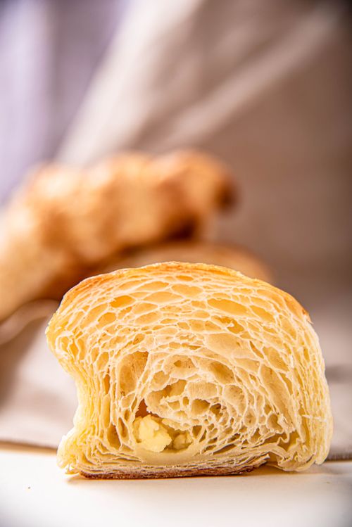 Free A delicious close-up view of a fresh croissant slice showing its flaky texture. Stock Photo