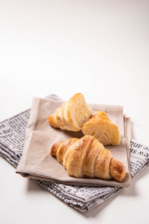 Free Delicious golden croissants on a fabric napkin, perfect for breakfast imagery. Stock Photo