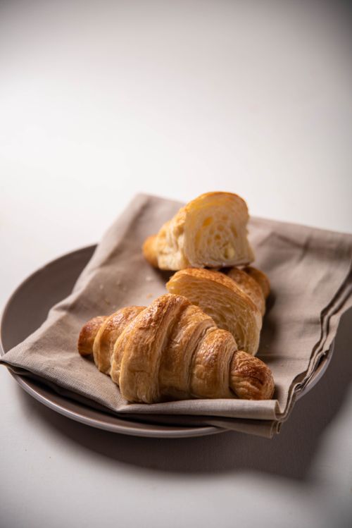 Free Delicious buttery croissants on a plate with a napkin, perfect for breakfast settings. Stock Photo