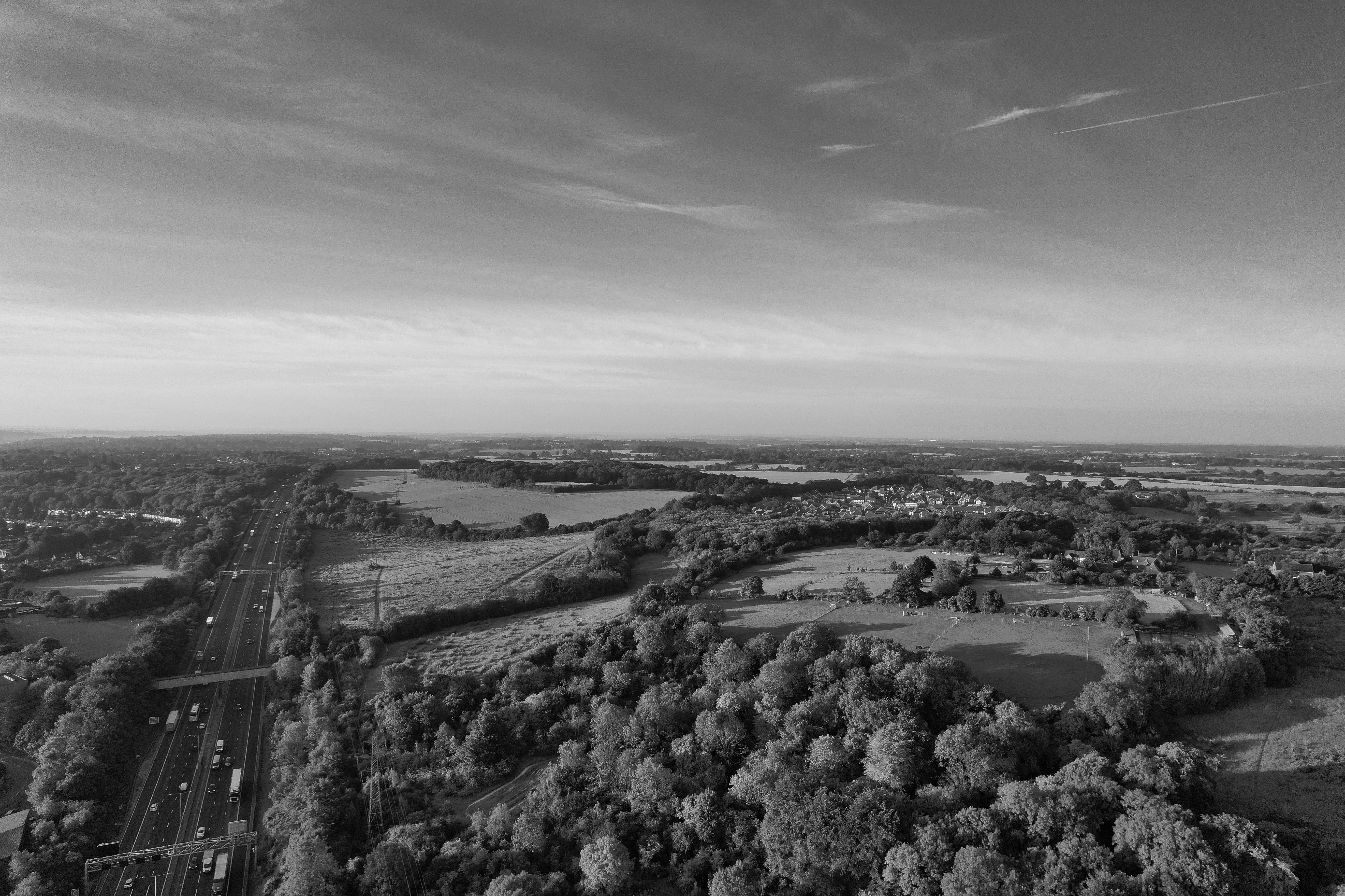 Amazing 35 Minute London Sightseeing Helicopter Tour Review: Soaring Over England's Iconic Capital Review 2026 - Black and white aerial view of the English countryside with a highway and fields.