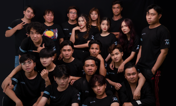 A group of diverse young adults posing together in a studio setting, wearing matching t-shirts.