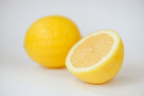 Free Bright yellow lemon sliced in half, highlighting its juicy interior on a white backdrop. Stock Photo