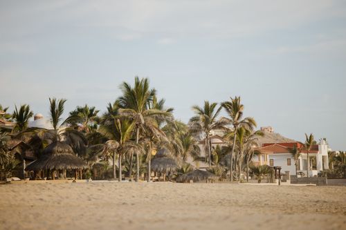 Free Tranquil beach scene with palm trees and villas at Casa Cyrene, Baja California Sur, Mexico. Stock Photo