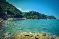 在充满活力的天空下，壮丽的岩石海岸线、郁郁葱葱的绿色悬崖和晶莹剔透的蓝色海水构成了一幅美景