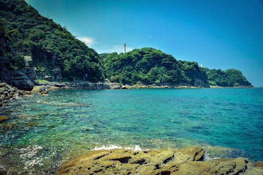 在充满活力的天空下，壮丽的岩石海岸线、郁郁葱葱的绿色悬崖和晶莹剔透的蓝色海水构成了一幅美景