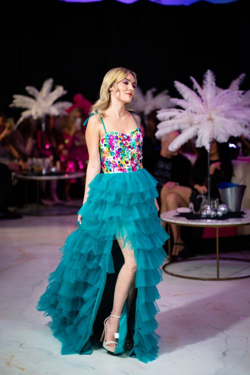 Free Fashion model in a colorful dress walking the runway during a vibrant fashion show. Stock Photo