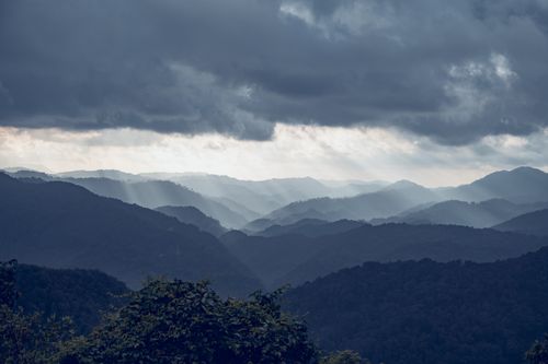 Free Stunning mountain vista with sun rays breaking through dramatic clouds. Stock Photo