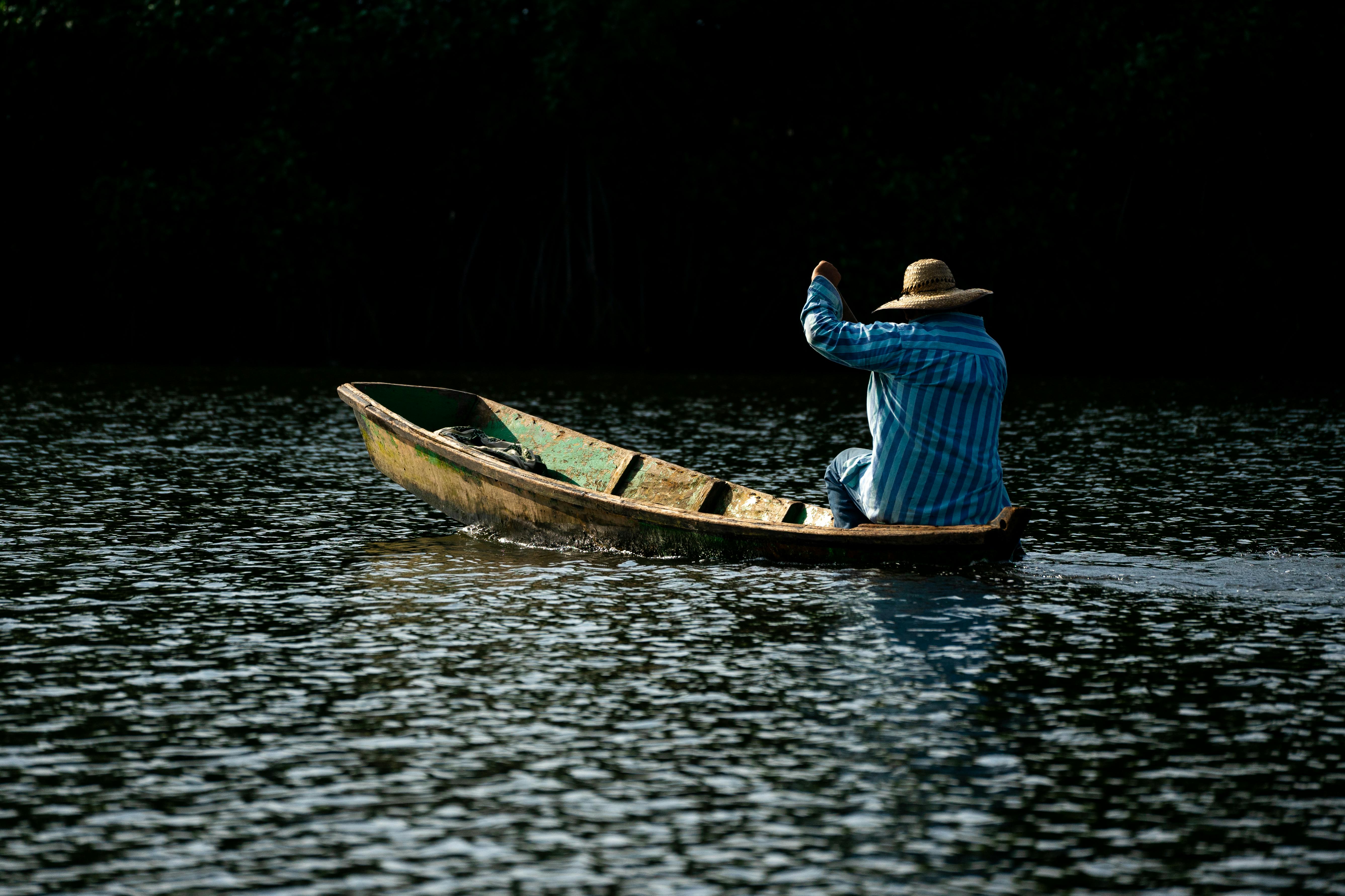 Man Rowing a Boat on a River Free Stock Photo