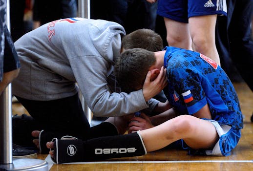A coach consoles a young athlete after a sports match, highlighting teamwork and motivation.