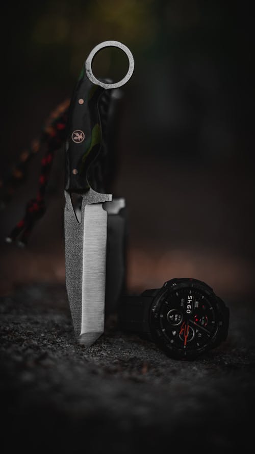 Silver Knife and Wristwatch on Dark Rock