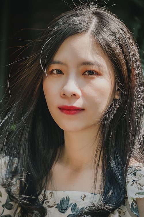 Free Close-up portrait of an elegant woman with long dark hair and red lips outdoors. Stock Photo