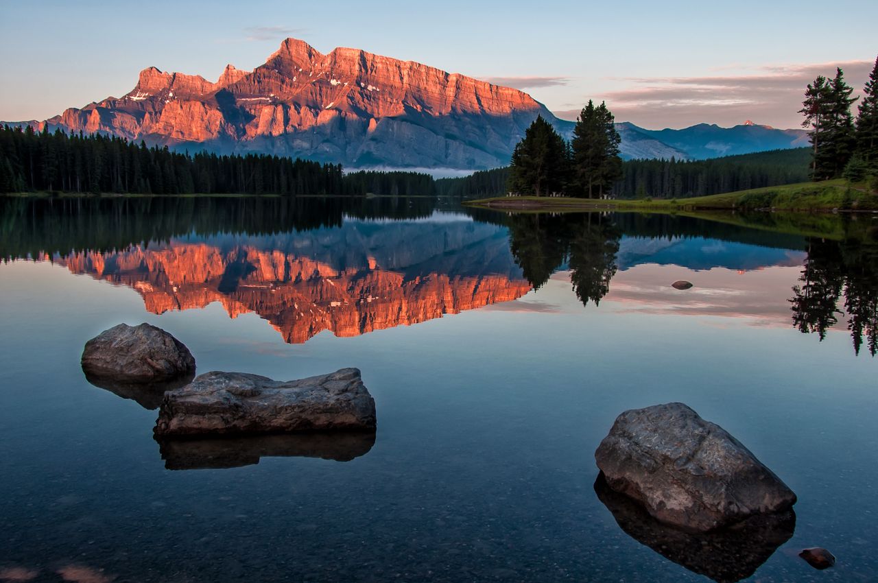 stunning view of a mountain reflecting in a calm lake during sunset in