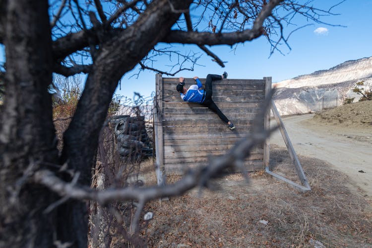 Man Climbing On Obstacle Course Wall