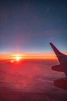 View of sunset from an airplane, highlighting a colorful sky over Lisbon, Portugal.