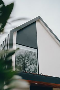 Sleek modern house facade featuring a large window and minimalistic design.