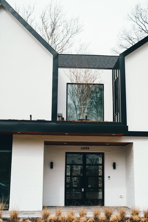Free Modern architectural facade with sleek design, featuring large windows and a stylish entrance. Stock Photo