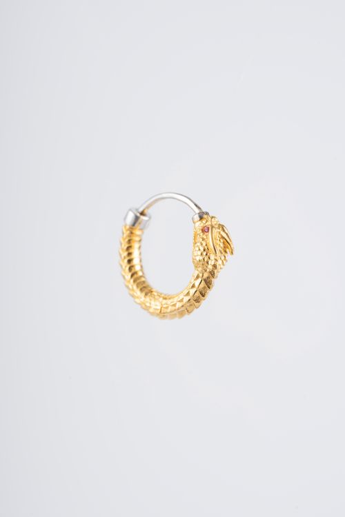 Free Close-up of a golden dragon-themed hoop earring on a white background. Stock Photo