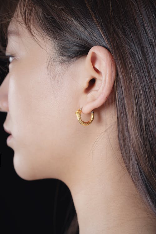 Close-up of Woman Wearing a Gold Earring with a Dragon Shape 