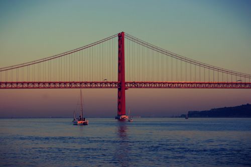 Free Beautiful sunset view of the 25th of April Bridge in Lisbon, showcasing its architectural elegance. Stock Photo