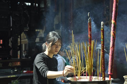 Woman Lighting Incense Sticks