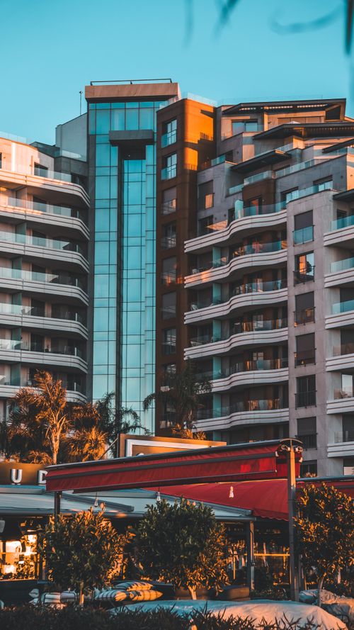 Free Contemporary skyscrapers basking in warm sunset hues, creating an urban cityscape. Stock Photo