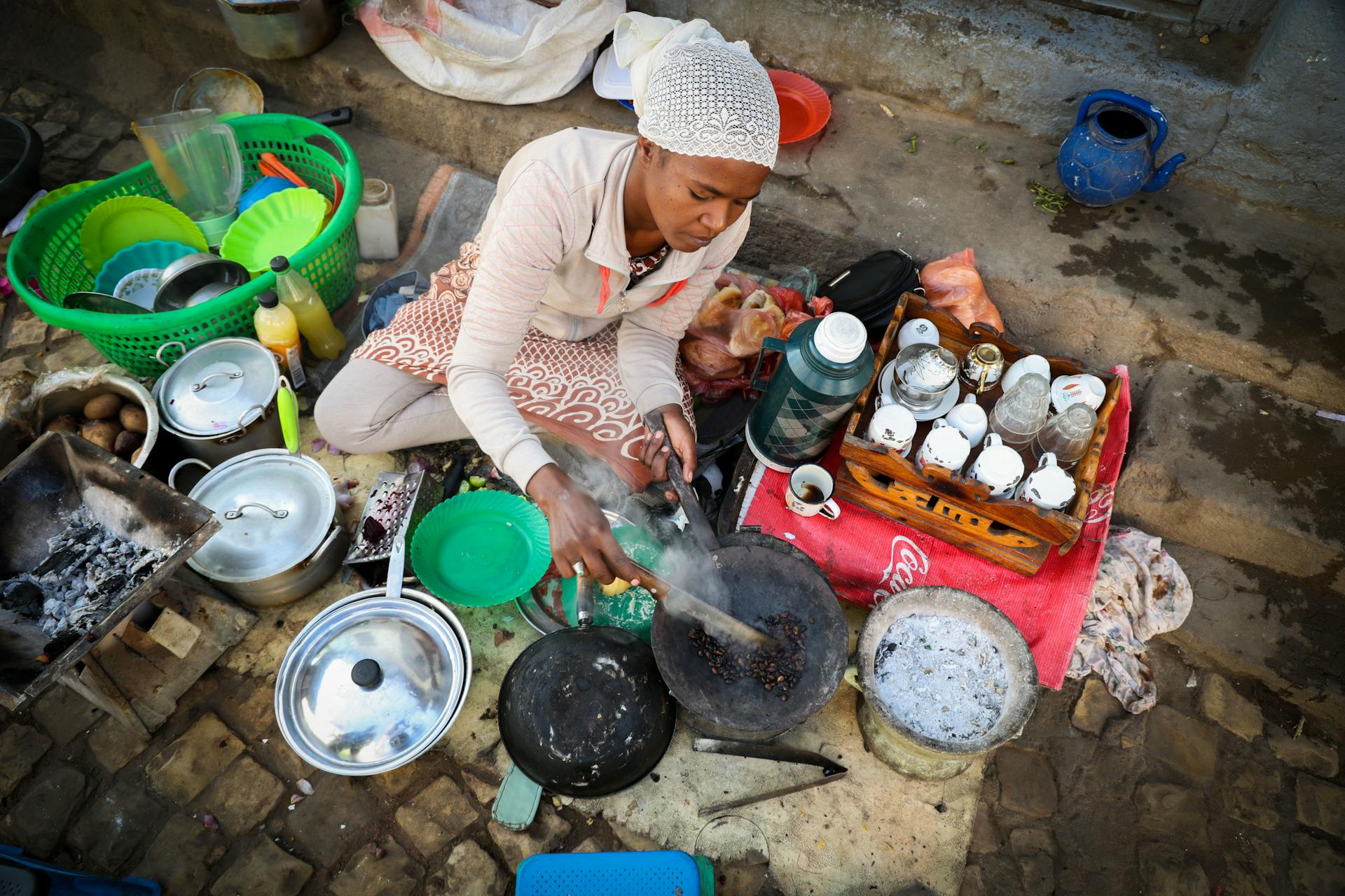 African woman roasts coffee beans on street in Addis Ababa, Ethiopia.