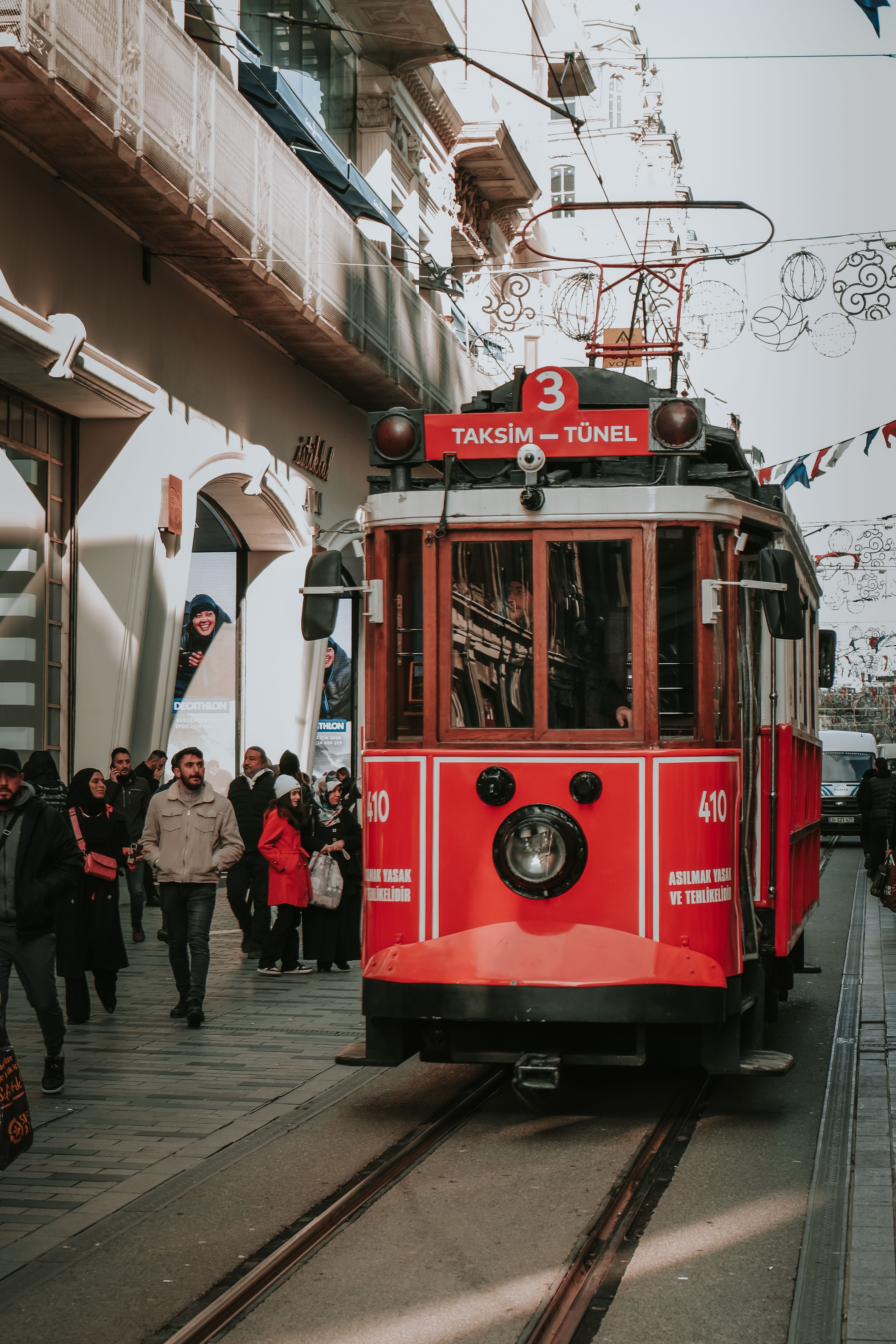 A red tram is traveling down a street · Free Stock Photo