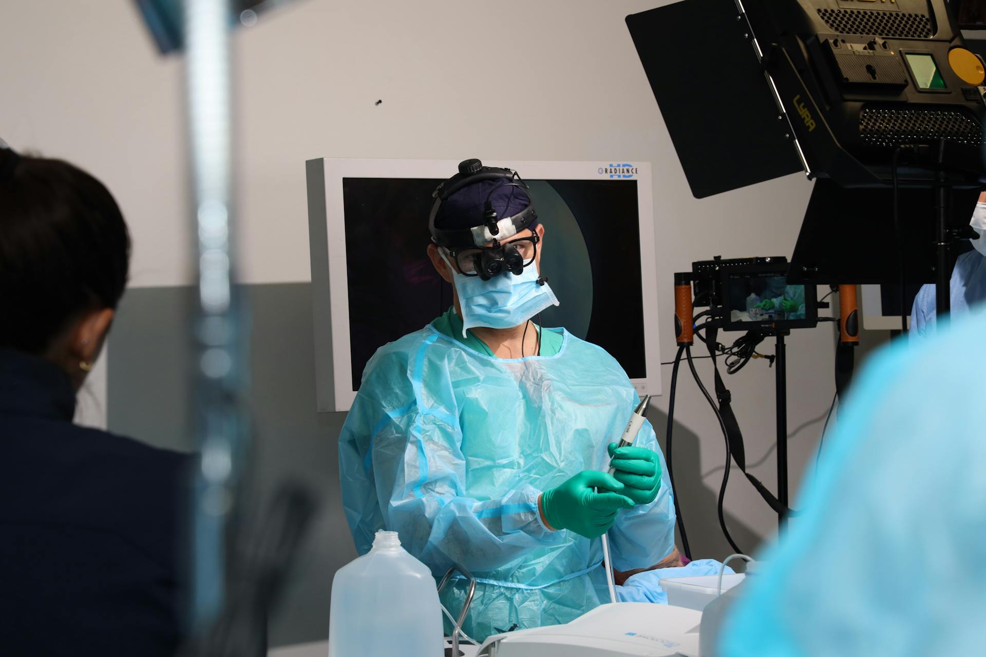 A surgical team performs a procedure in a sterile operating room environment.