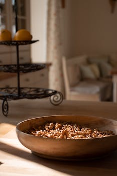 Warm kitchen scene featuring a wooden bowl of walnuts in sunlight, perfect for healthy living concepts.