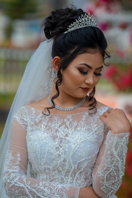 Free Beautiful bride posing in a lace gown with a tiara, showcasing elegant bridal fashion. Stock Photo