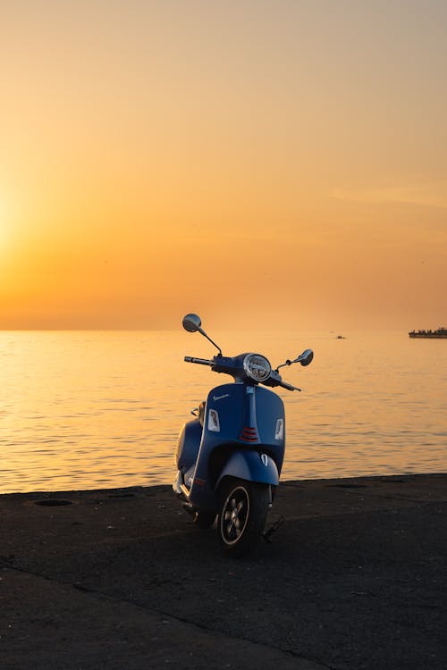 Parked vespa scooter during sunset near seaside