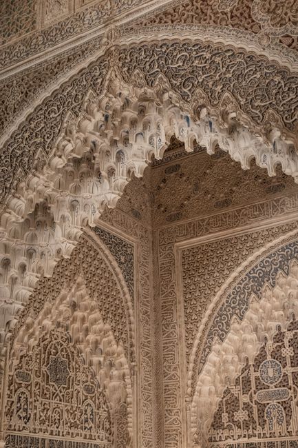 Detailed arabesque architectural design in Alhambra, Spain showcasing Islamic art style.