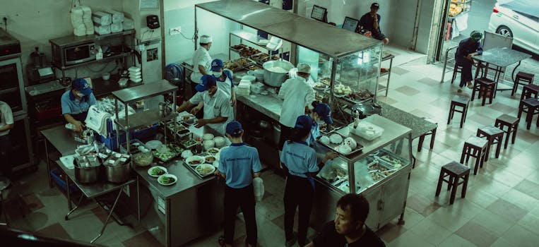 Chefs preparing meals in a local eatery kitchen, seen from above.