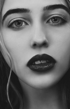 Close-up black and white portrait of an elegant woman with striking eyes.