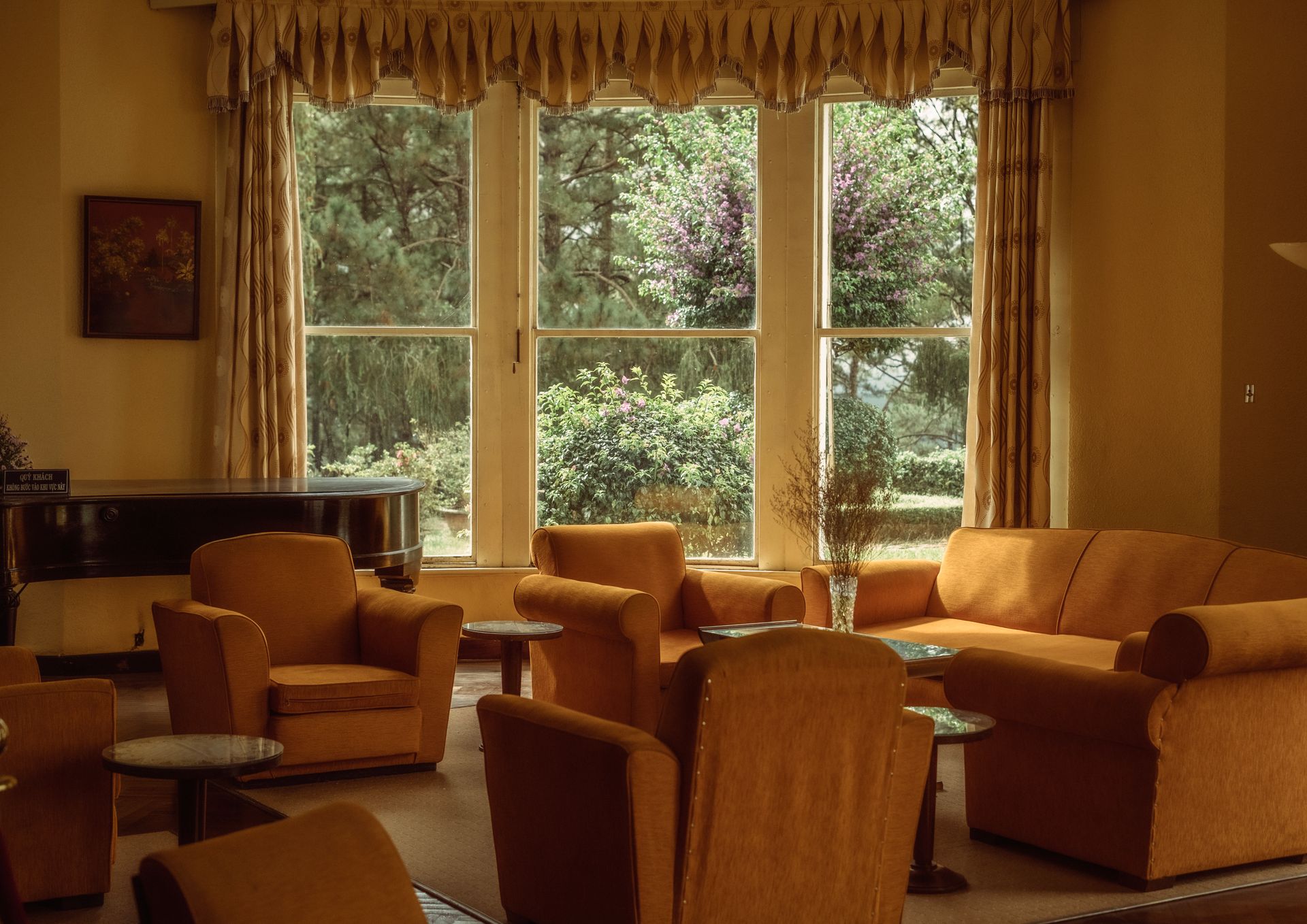 A warm and inviting retro living room featuring vintage furniture and a large window with a scenic view.