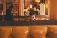 餐厅内温暖迷人，一位女士坐在展位上